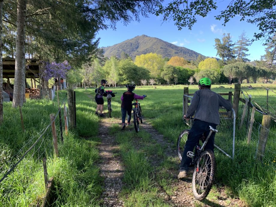 Image Of Cyclists On Baton River Property With Mountain In The Background